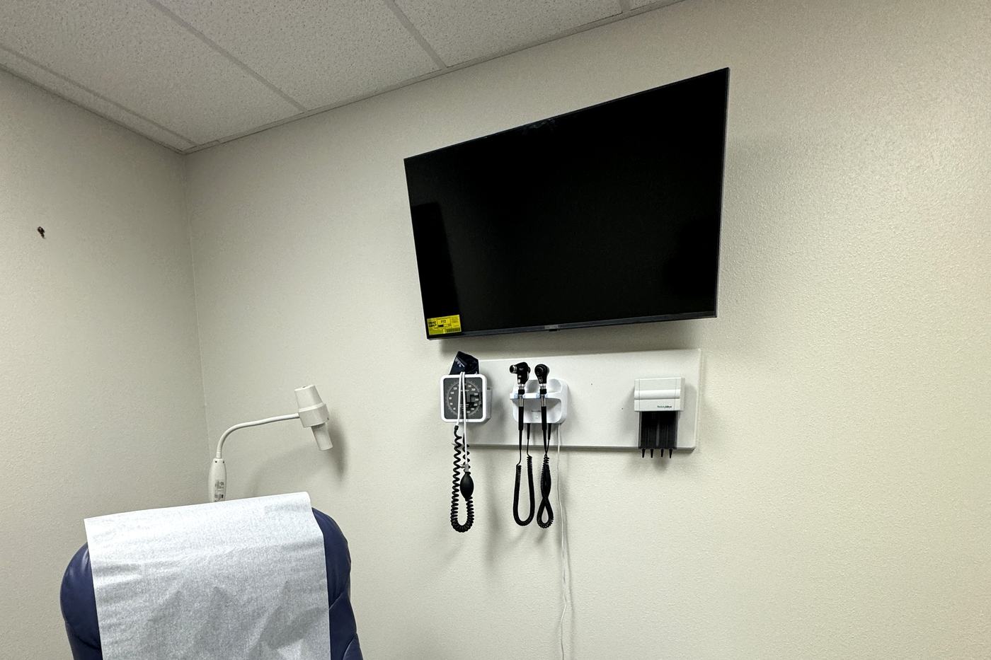 Wall-mounted display installed in a medical exam room by Allied Technologies